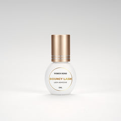 BouncyLash Power Bond lash extension adhesive in a white 5 mL bottle with a gold cap.