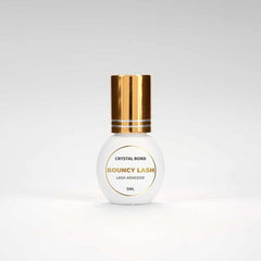 BouncyLash Crystal Bond clear lash extension adhesive in a white 5 mL bottle with a gold cap.