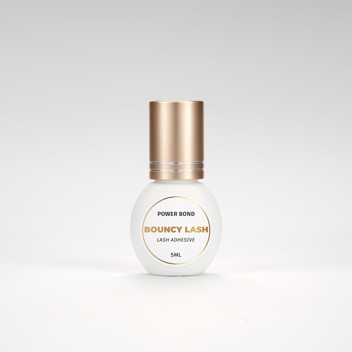BouncyLash Power Bond lash extension adhesive in a white 5 mL bottle with a gold cap.
