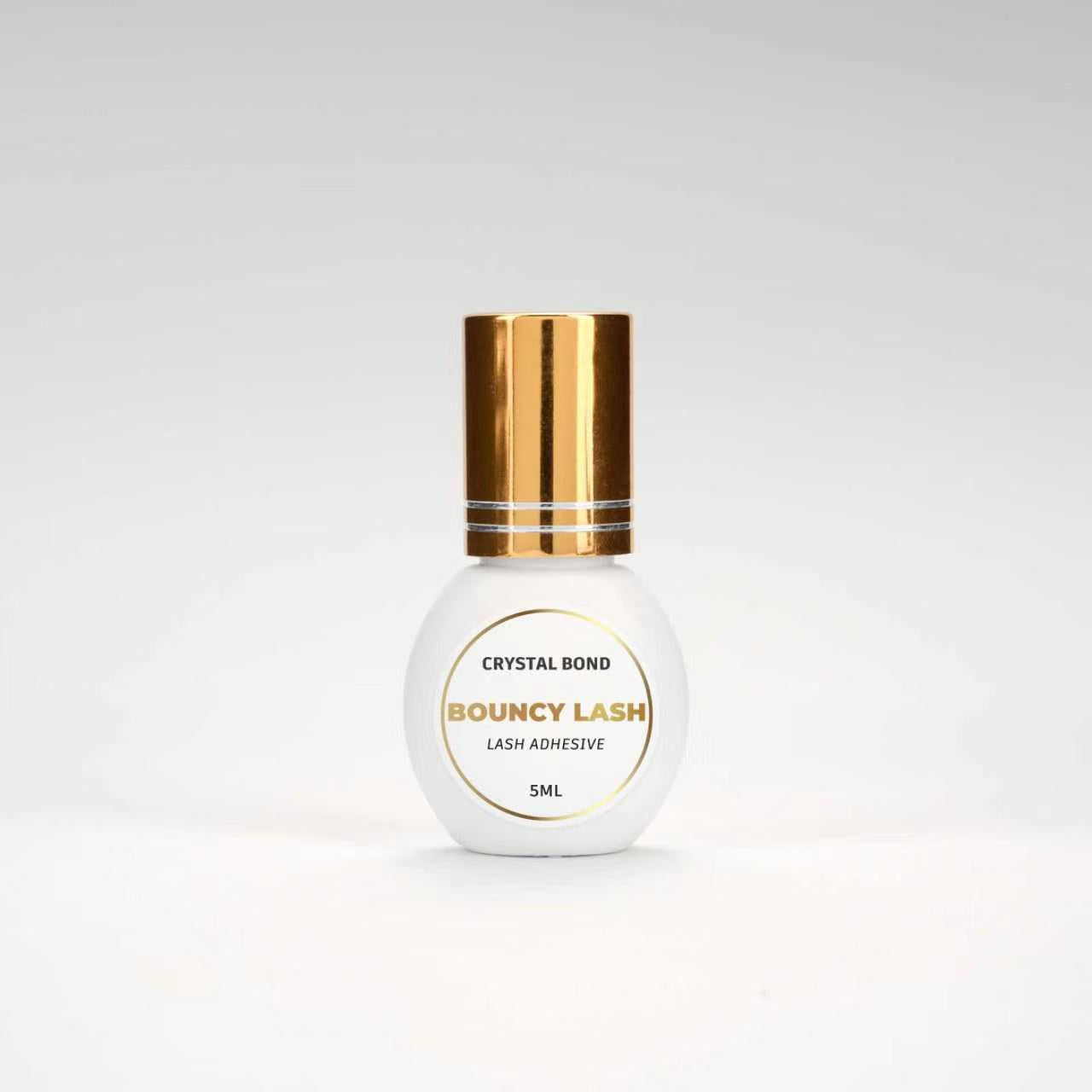BouncyLash Crystal Bond clear lash extension adhesive in a white 5 mL bottle with a gold cap.
