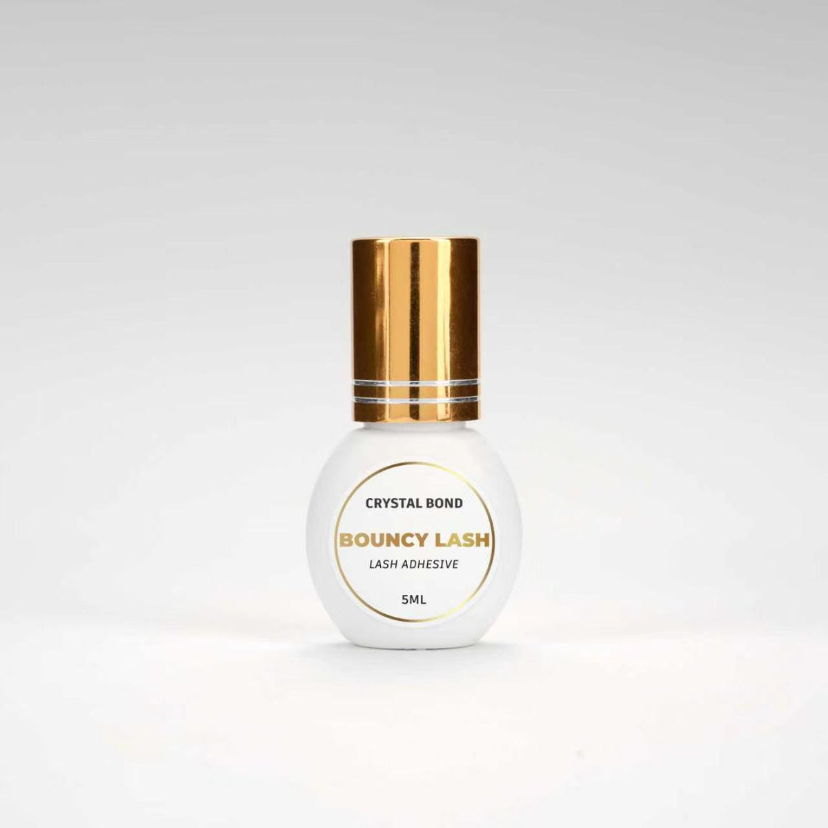 BouncyLash Crystal Bond clear lash extension adhesive in a white 5 mL bottle with a gold cap.